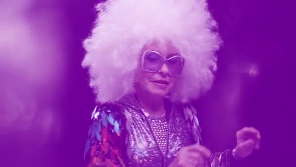 Старша жінка танцює в дискотеці з навушниками — стокове відео