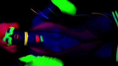 Ultraviyole ışıltılı kadın dansçının dikey videosu