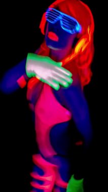 Ultraviyole ışıltılı kadın dansçının dikey videosu