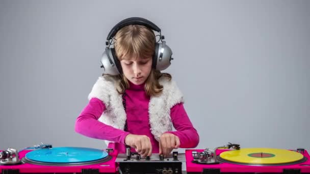 Flicka med hörlurar runt halsen spelar skivor — Stockvideo