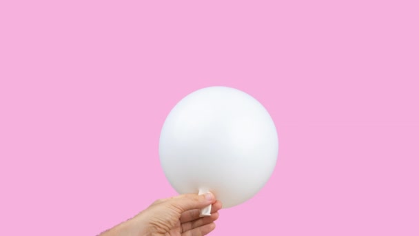 Weißer Luftballon wird vor rosa Hintergrund gesprengt — Stockvideo