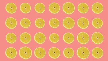 Pembe arkaplana karşı sıralanmış limonlar