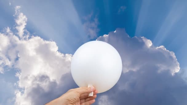 Белый шар взрывается на фоне неба с облаками — стоковое видео