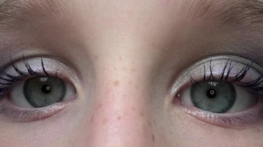 Genç kız kameraya bakıyor.