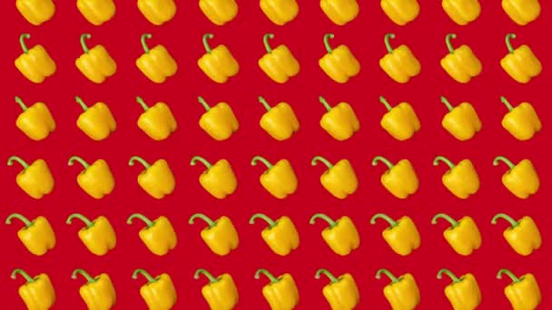 Pimentos amarelos caindo contra um fundo vermelho — Vídeo de Stock