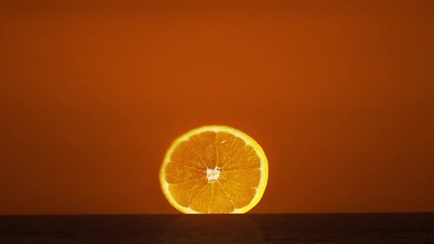 Naranja rebanada puesta como el sol sobre el horizonte — Vídeos de Stock