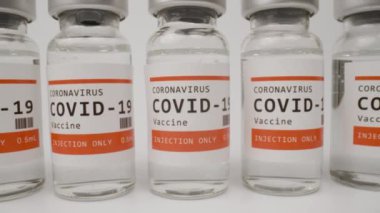 Beyaz arka plana karşı covid-19 aşısı şişeleri 