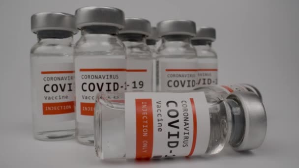 Glazen injectieflacons met het covid-19 vaccin tegen witte achtergrond — Stockvideo