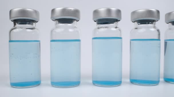 Glazen injectieflacons met blauw gekleurde vloeistof — Stockvideo
