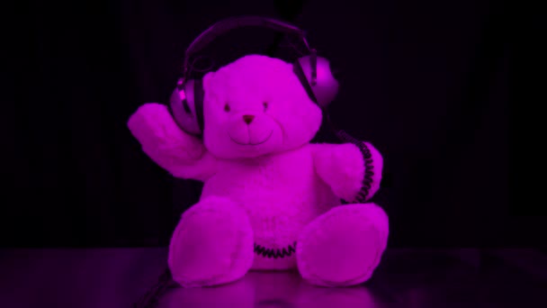 Teddy beer beweegt rond met hoofdtelefoon — Stockvideo