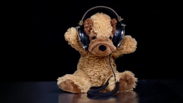 Плюшевий собака рухається з навушниками — стокове відео