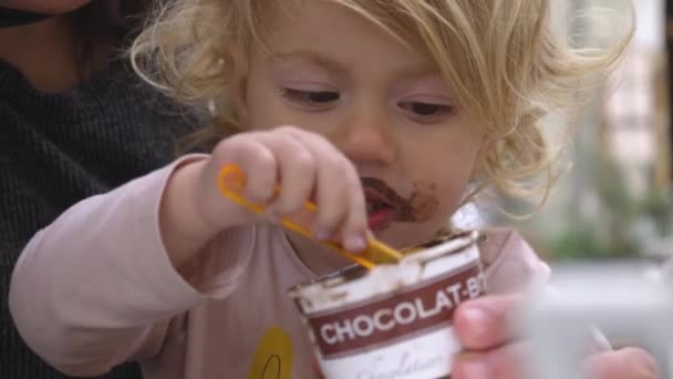 Bebé comiendo helado de chocolate — Vídeo de stock