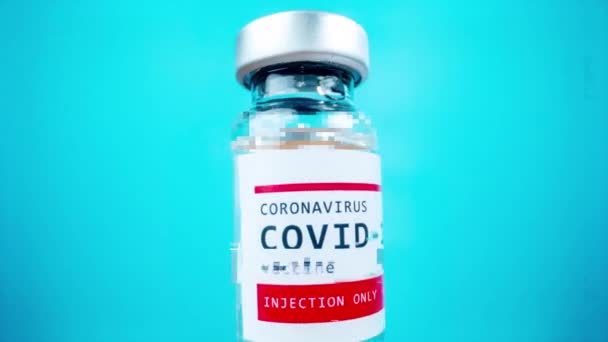 Flacon en verre du vaccin covid-19 sur fond bleu — Video