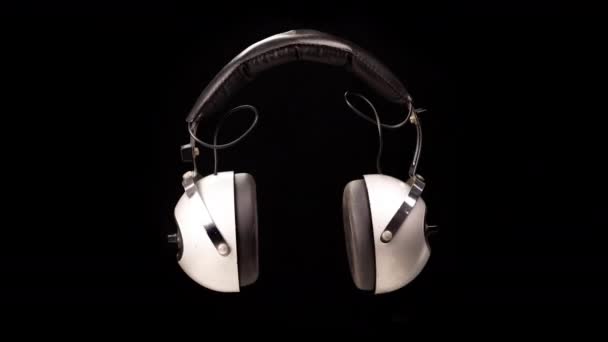 Fones de ouvido vintage contra fundo preto — Vídeo de Stock