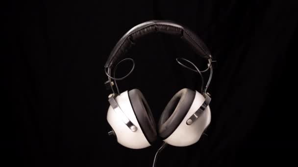 Fones de ouvido vintage contra fundo preto — Vídeo de Stock