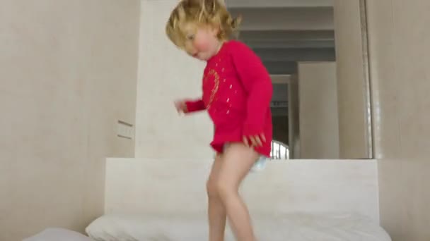 Küçük kız yatakta zıplıyor. — Stok video