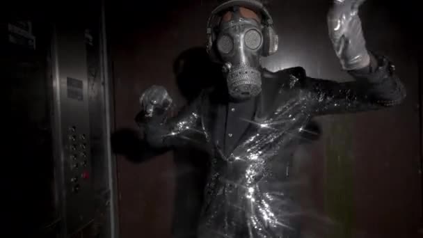 Hombre con máscara de gas brillante bailando en un ascensor — Vídeo de stock