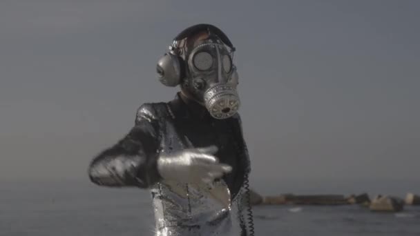Köpüklü gaz maskeli adam deniz kenarında dans ediyor. — Stok video