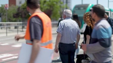 Barselona 'da insanlar tramvay durağından geçiyorlar.