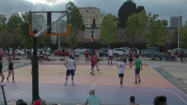 Adultos jóvenes jugando al baloncesto al aire libre — Vídeos de Stock