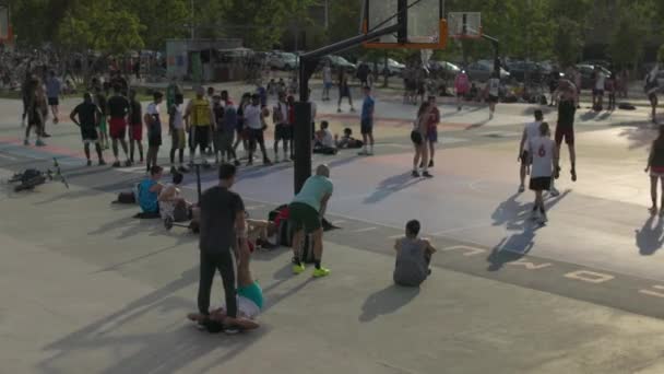 Young adults playing basketball outdoors — Vídeo de Stock