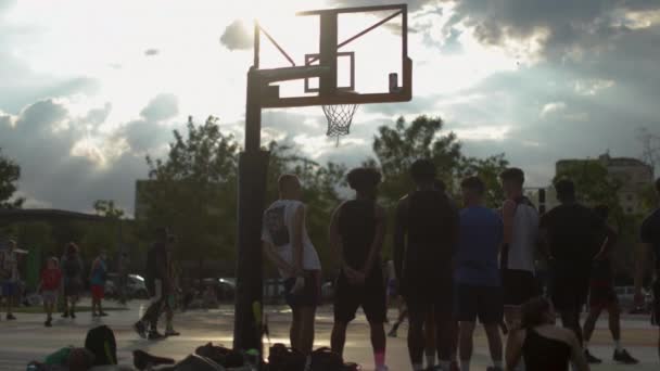 Adultos jóvenes jugando al baloncesto al aire libre — Vídeo de stock