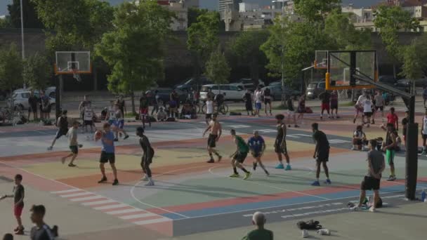 Jonge volwassenen die buiten basketbal spelen — Stockvideo