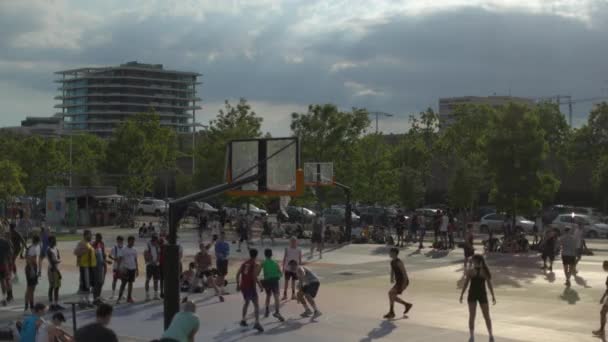 Adultos jóvenes jugando al baloncesto al aire libre — Vídeos de Stock