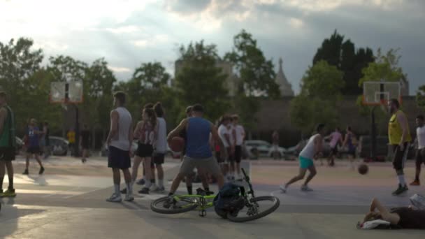 Young adults playing basketball outdoors — Stock Video