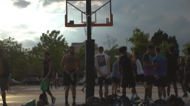 Jonge volwassenen die buiten basketbal spelen — Stockvideo