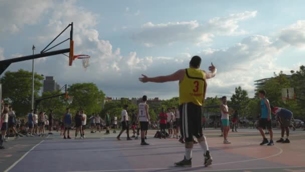 Adultos jóvenes jugando al baloncesto al aire libre — Vídeos de Stock