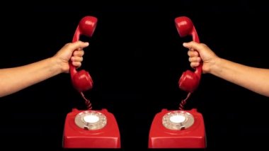 Elinde retro kırmızı bir telefonun alıcısı var.