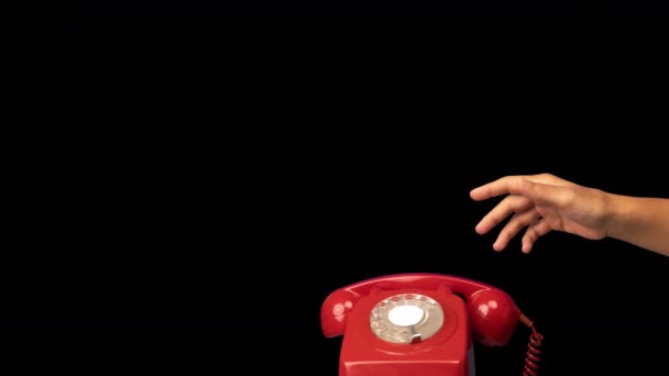 Tenere in mano il ricevitore di un telefono rosso retrò — Video Stock