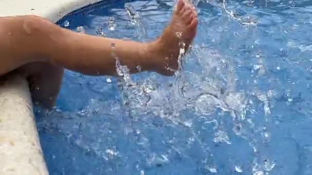 Kind spetterende voeten in het zwembad water — Stockvideo