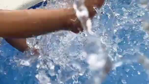 Child splashing feet in swimming pool water — Stock Video