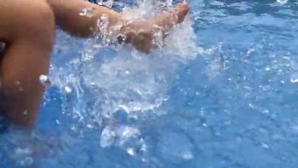 Yüzme havuzunda ayakları sıçrayan çocuk — Stok video