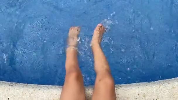 Rozbryzgane stopy dziecka w wodzie basenowej — Wideo stockowe