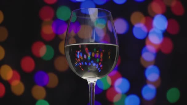 Vinho branco em vidro com luzes embaçadas — Vídeo de Stock