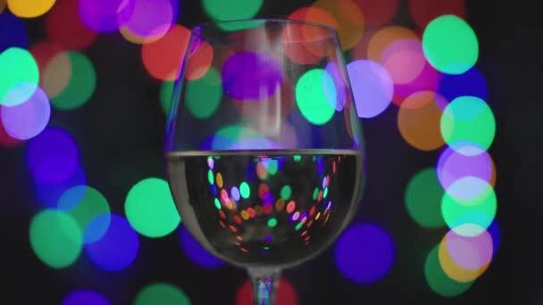 Vino blanco en copa con luces borrosas — Vídeo de stock