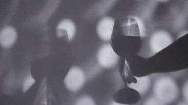 Şarap kadehlerini tutan ellerin gölgesi