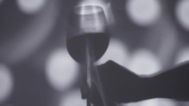 Şarap kadehini tutan elin gölgesi