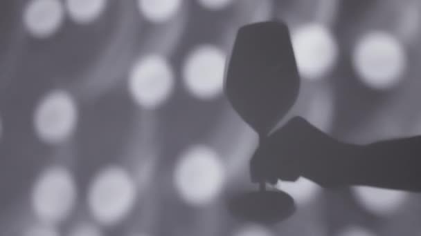 Sombra de mano sosteniendo una copa de vino — Vídeo de stock
