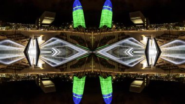 Timelapse of Glories Metro Station In Barcelona and skyline and torre agbar lit up at night made into abstract pattern