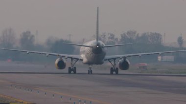 Havaalanındaki uçak pistinde ağır çekimde taksicilik yapıyor.