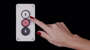 Kadın eli bir endüstriyel asansör aşağı düğmesine basıyor. 