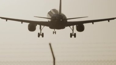 Uçak gün batımında çok yavaş çekimde havaalanına inecek.