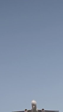 Günbatımında dikey olarak süper yavaş çekimde havalimanına iniş yapmak için üzerimizden uçan uçak