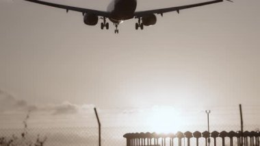 Uçak gün batımında çok yavaş çekimde havaalanına inecek.