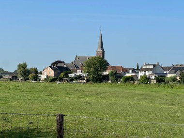 Beesd 'deki Katolik kilisesi manzarası, bu Hollanda köyünün simgesi. Görüntü, yerel miras, inanç ve tarihi yansıtan sakin kırsal bir ortamda geleneksel kilise mimarisini gösteriyor..