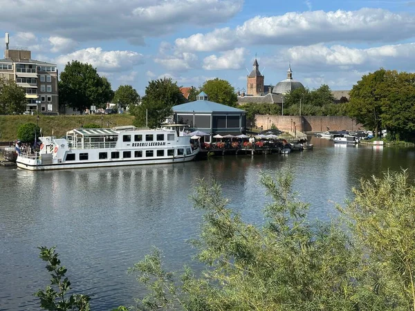 Linge nehri boyunca Leerdam 'ın tarihi şehir duvarının manzarası. Sahne, ortaçağ tahkimatları, akan sular ve Hollanda tarihi ve mirasını yansıtan sakin bir manzaranın birleşiminden oluşuyor.